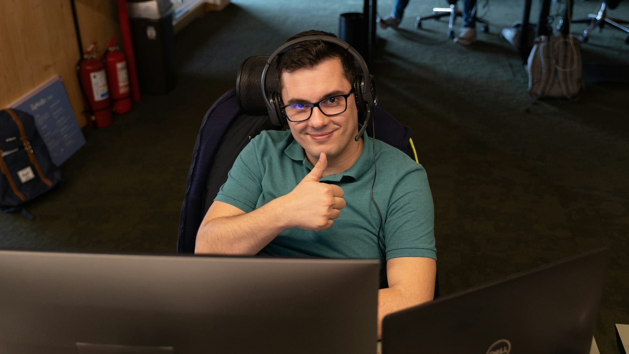 a man wearing headphones sitting in front of a computer